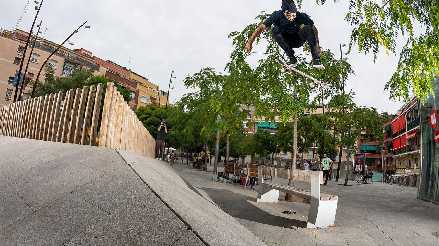 Enzo Cautela Performing a backside 180 kickflip over a bench from a bank
