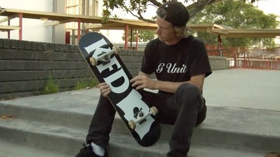 Jeff DeChesare sitting at the top of a stair set inspecting his fresh KFD Flagship Deck