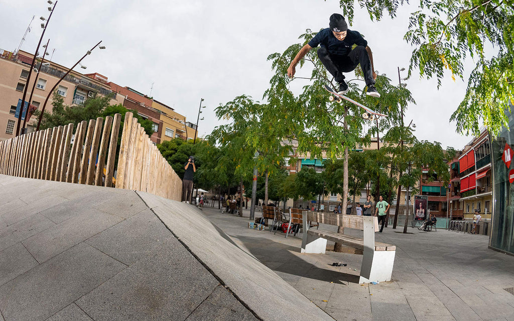 Enzo Cautela Performing a backside 180 kickflip over a bench from a bank
