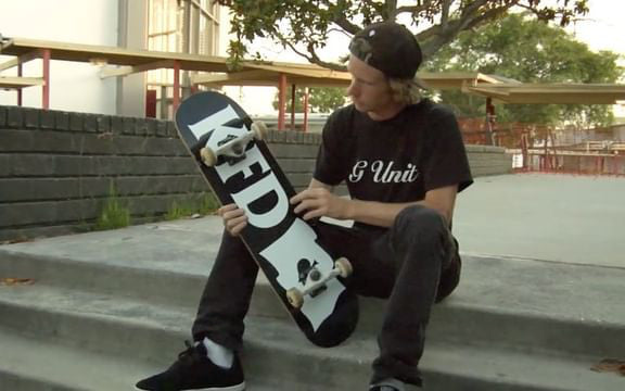 Jeff DeChesare sitting at the top of a stair set inspecting his fresh KFD Flagship Deck